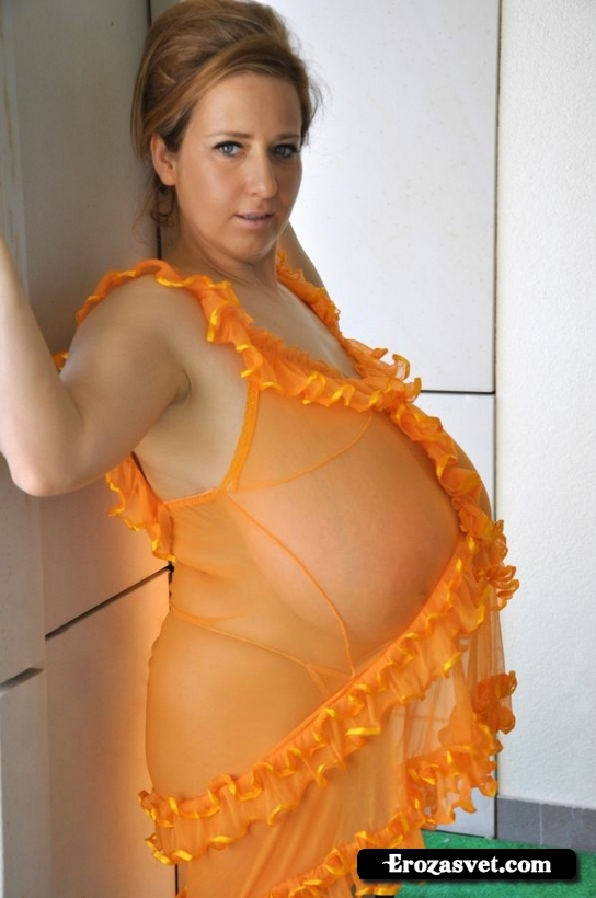 Женщина с огромными грудями в оранжевом прозрачном пеньюаре