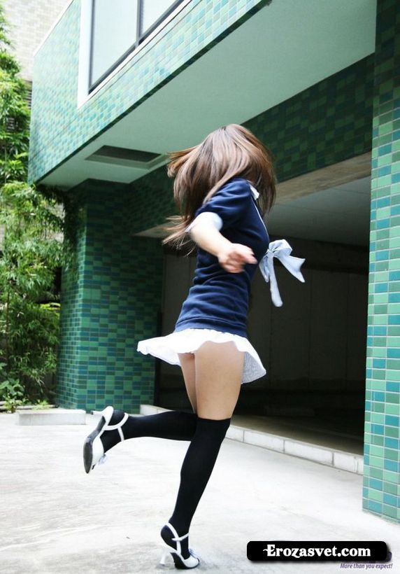 Молодая китаянка в черных чулочках и короткой юбке на улице