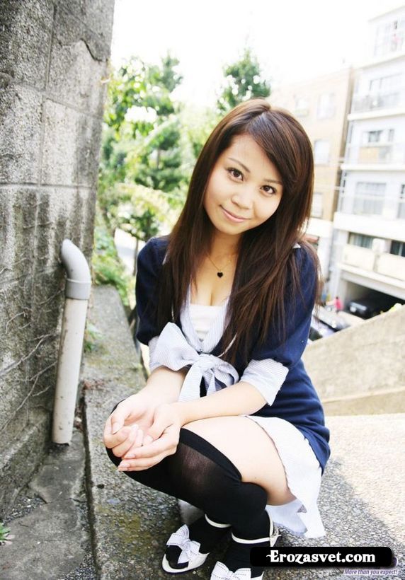 Молодая китаянка в черных чулочках и короткой юбке на улице